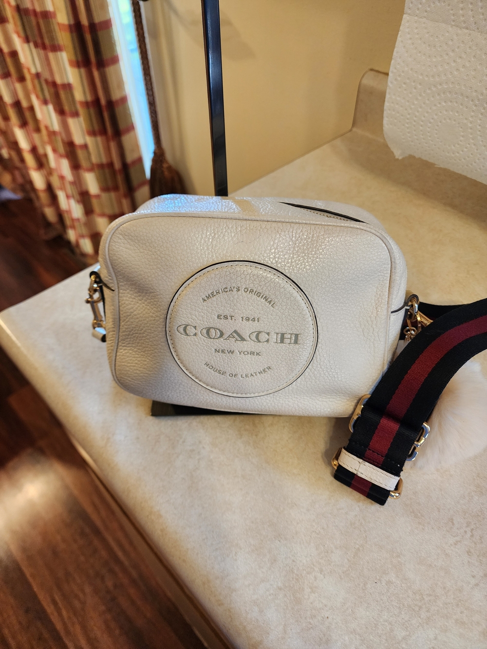 Coach Dempsey Camera Bag is white refined pebble leather